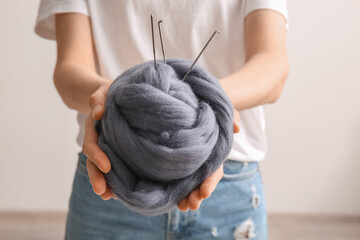 Woman holding wool for felting with needles on light background, closeup © Pixel-Shot
