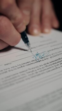 Close up of hand signing signature on official business document, concept of agreement, contract approval and legal paperwork.