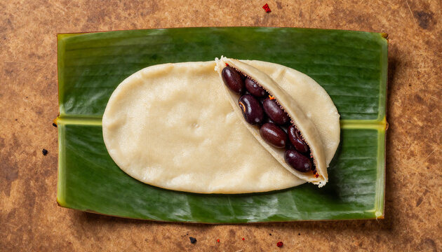 flat lay of Nigerian moi moi sliced open showing smooth bean texture, served on banana leaf surface, subtle red pepper flecks visible