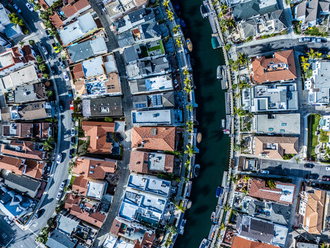 Elevated aerial view of Long Beach canal district with waterfront homes, bridges and tightly packed coastal residential neighborhood