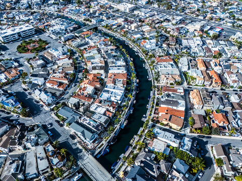 Elevated aerial view of Long Beach canal district with waterfront homes, bridges and tightly packed coastal residential neighborhood