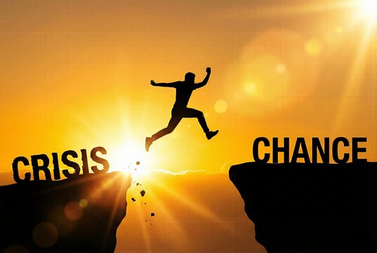 Silhouette of businessman jumping across cliff gap from crisis to chance representing corporate risk management overcoming adversity financial recovery brave leadership and career opportunity.