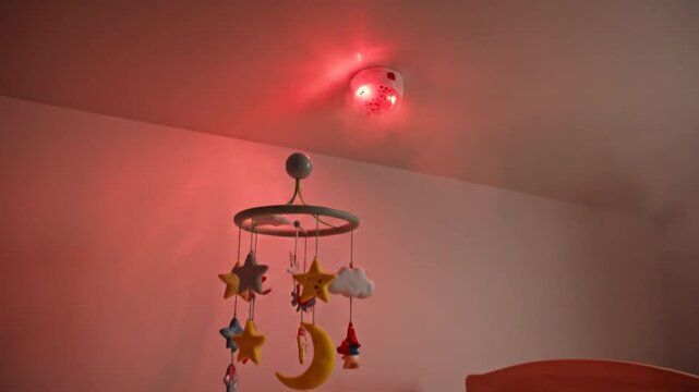 Baby nursery room with wooden crib and smoke cloud from ceiling emergency