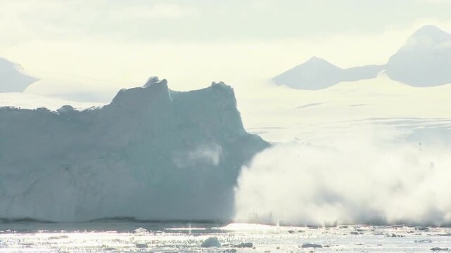 Massive iceberg crashing into frigid Arctic ocean, dramatic ice fracture and melt, glacial movement, climate change concept, pristine polar wilderness, daylight reflections.
