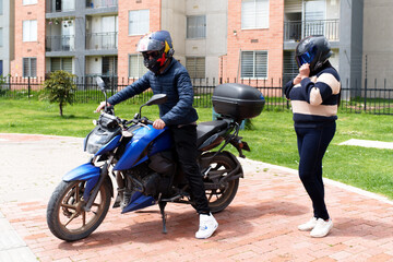 People wearing helmets preparing to ride a motorcycle on an urban street © fx-visual