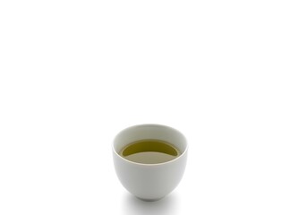 Obraz premium A small white bowl filled with green liquid