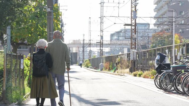 寄り添って街を歩くシニアカップル