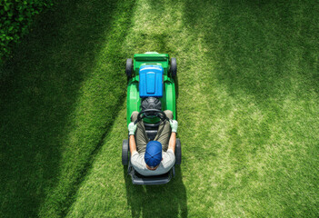 Lawn Care Professional Mowing Grass in a Well-Maintained Garden