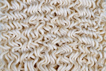 Closeup of crispy noodles surface. Detailed view of ridged dry noodles texture. High magnification revealing porous surface and tactile ridges of instant noodles