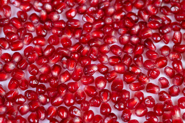 Minimalist seed pattern. Bright pomegranate seeds with contrast. Symmetrical macro design of pomegranate seeds. Modern flatlay featuring high contrast pomegranate seed arrangement