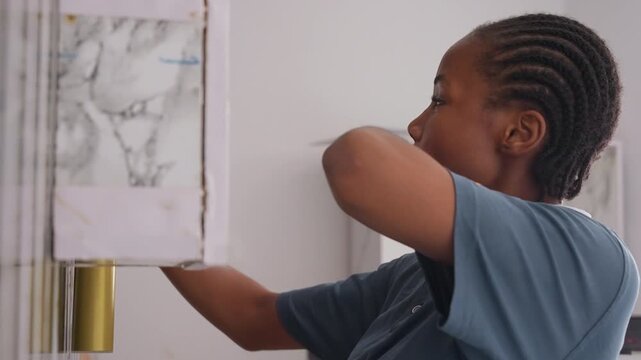 Black girl adjusting lamp in house, focused expression, marble lamp base, reaching arm, tidy polo uniform, braided hair, soft daylight, living room corner, household chore, quiet concentration