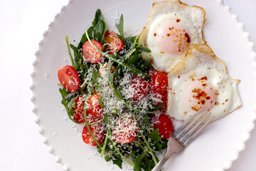 Healthy Breakfast with Fried Eggs and Green Salad on White Background.