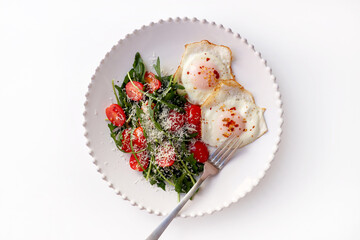 Healthy Breakfast with Fried Eggs and Green Salad on White Background.