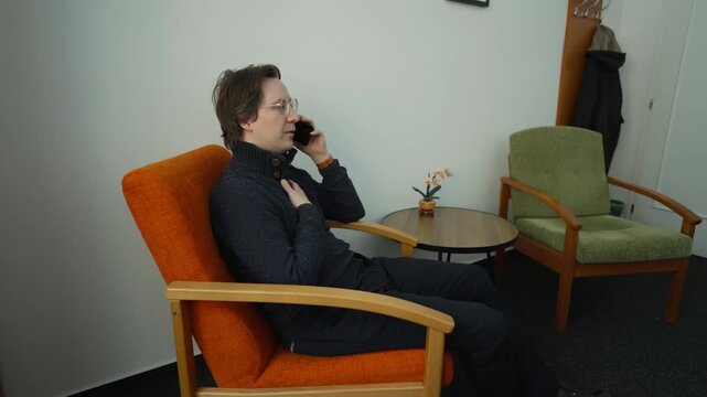 A man is on the phone and receives reassuring news. A noticeable emotional relief from good and expected information.