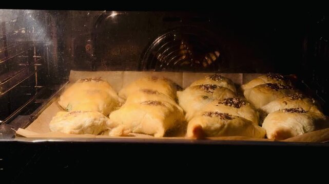Timelapse video of traditional Uzbek samsa rising and browning in the oven. Flaky pastry pies baking for Iftar during the holy month of Ramadan. Homemade halal food process for evening celebration.