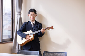 教室でギターを弾く男子学生