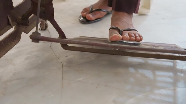 Closeup sandal on treadle pedal, antique black sewing machine on sunlit house floor, foot pressing rhythmic motion, toe gripping sandal strap, cast iron pattern, quiet domestic chore, handmade garment