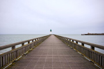 Fototapeta premium Long pier reaching lighthouse over calm sea Calais France