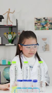 Young Asian Girl Conducting Bernoulli's Principle Science Experiment with Ping Pong Ball