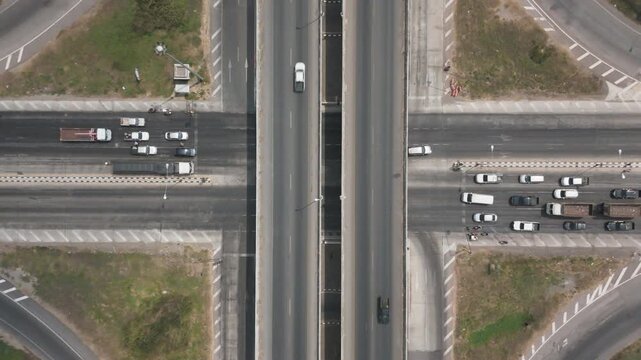 Aerial view of modern highway interchange with multilayer roads and curved ramps surrounded by green farmland, showcasing transportation infrastructure, urban development, and road network planning.