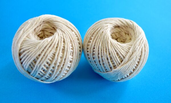 Balls of twine isolated against a plain background.