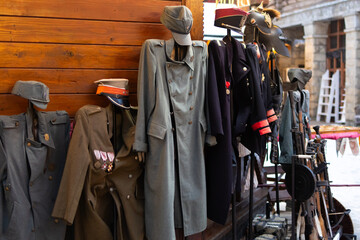  An open stall presents coats hats and period attire along a snowy street while nearby tables hint at props and replicas creating a scene of history and craftsmanship ready for visitors
