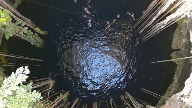 People swimming in Cenote Ik Kil near Chichen Itza in Mexico