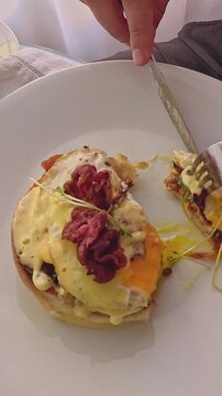Overhead view eating croque monsieur showing eggs and creamy sauce, a popular french dish for breakfast