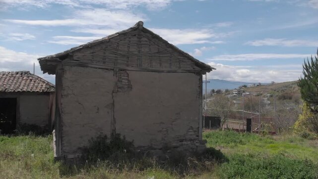 Front view of an abandoned house in ambato near a road over a green grass terrain