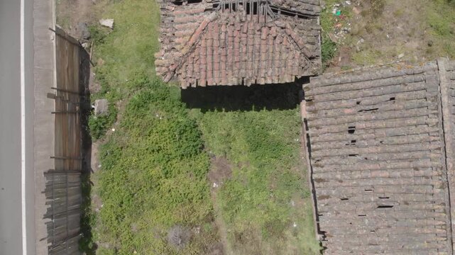 Wide view of an abandoned house in ambato near a road over a green grass terrain