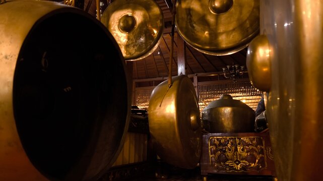 Close up perspective of heritage Javanese gamelan instruments arranged in ceremonial formation, traditional percussion sound culture, historical music legacy, authentic Indonesian art tradition.