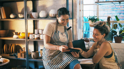 Reading, ceramic or team in store with tablet, creative insight or customer review in clay shop....