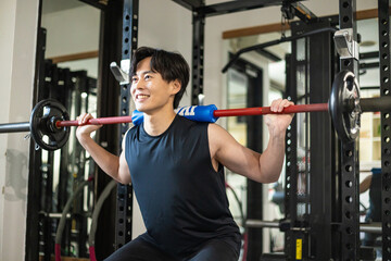 バーベルを担ぐ男性