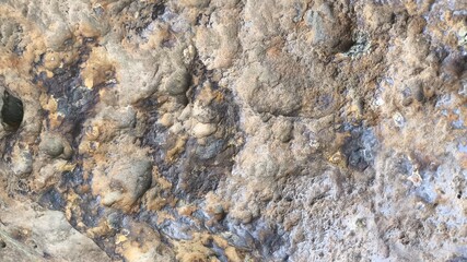 Obraz premium Detailed stone texture background showing rugged rock wall surface, abstract grungy material pattern suitable for construction projects, vintage design, and natural textured layouts