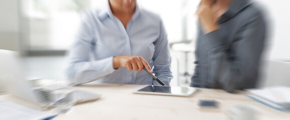 Blurred motion of business people having a meeting with digital tablet