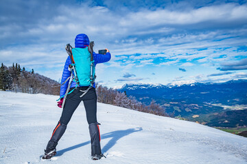 A young woman walking in the snow with a backpack