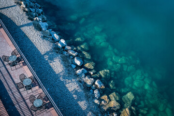 Beach with large rocks and a few tables of resort