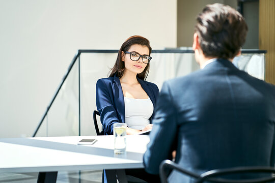 Businesswoman and businessman talking at desk in modern office