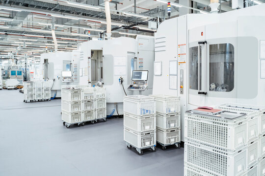 Crates stacked in front of industrial machinery inside modern factory, Stuttgart, Germany