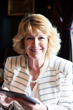 Portrait of smiling senior businesswoman holding tablet