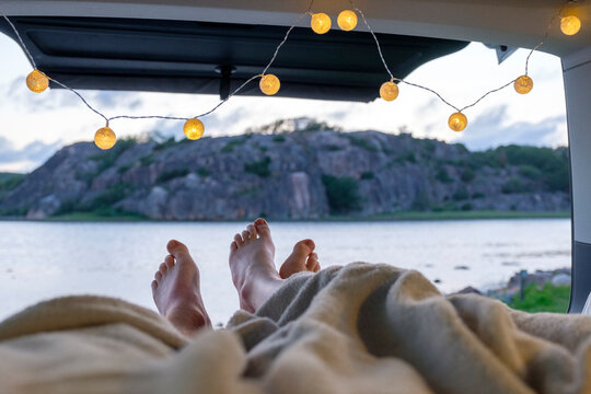 Feet of teenage couple, lying in a camper at the sea