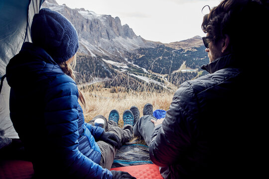 Couple sitting in tent in the mountains looking at view
