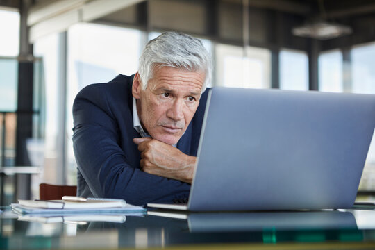 Businessman sitting at desk, trying to solve a problem