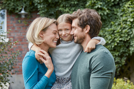 Portrait of happy family in garden of their home