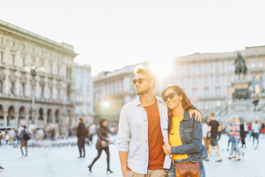 Happy young couple on a square in the city at sunset, Milan, Italy