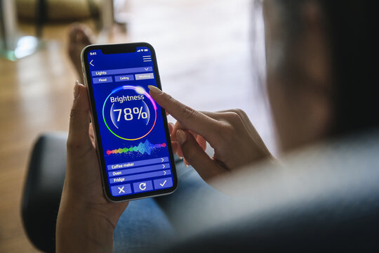 Young woman with smartphone with smart home control functions