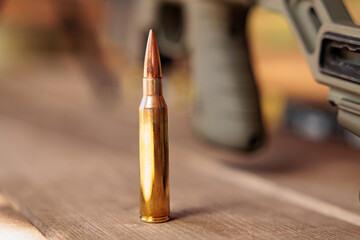 Obraz premium cartridge for sniper rifle on a wooden surface
