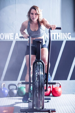 Young woman on exercise machine in gym