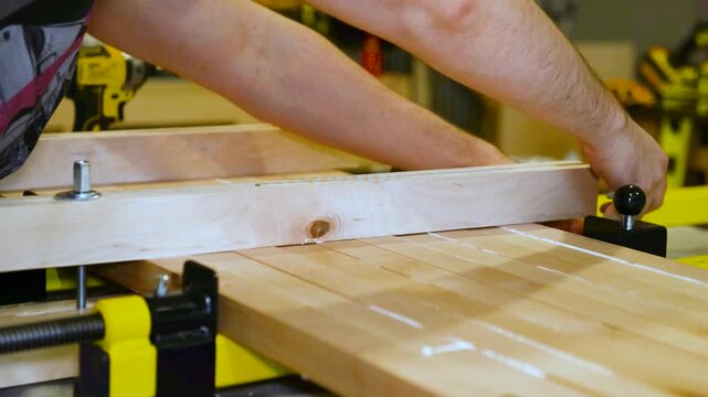 Set of clamps tools instruments for compressing and gluing wooden beams on work table in carpentry workshop, small business woodshop creating handmade items and furniture for home and living.
