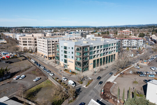 Aerial drone view of City of Beaverton civic complex with Building Department offices and Central MAX light rail station in Oregon USA. Urban infrastructure, rail tracks and rooftop solar panels 